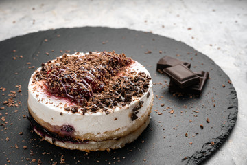 Cake with mousse and jam near the pieces of chocolate