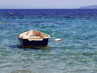 barchetta solitaria nel mare estivo limpido e trasparente