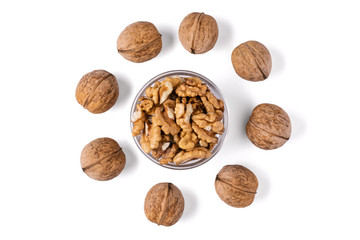 Whole and chopped walnuts in a glass bowl arranged in a circle. Isolated on white background