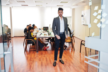 Fototapeta na wymiar Face of handsome asian business man, holding laptop on the background of business peoples multiracial team meeting, sitting in office table.