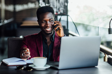 Successful male freelancer connecting to wireless via laptop,holding phone, thoughtful businessman...