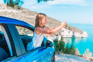 Little girl on vacation travel by car. Summer holiday and car travel concept