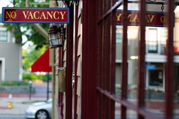 Vacancy Sign Outside of Hotel With Red Windows and Reflections