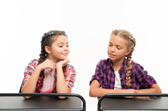 Cheating on the exam. Little schoolchildren passing exam isolated on white. Small girl peeping at her classmate during exam. Their first exam