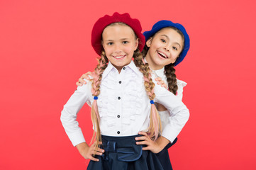 Girls best friends on red background. True friends always stand beside you. Cute playful sisters schoolgirls having fun. Friendship means support. Kids long braids hairstyle classmates friends