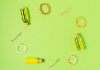 Fototapeta na wymiar Flat lay of hair care products and styling items on green background. Women beauty and beauty salon cosmetics concept. Copy space.