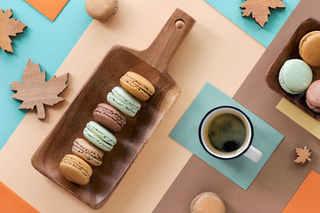 Macarons and expresso, flat lay on geometric paper background with Autumn decorations