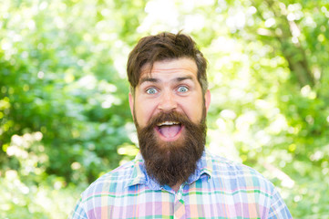 Fototapeta premium Being good spirits. Happy hipster on summer day. Bearded man smiling in trendy hipster style on natural environment. Brutal guy in casual hipster style. Hipster wearing thick beard and stylish hair