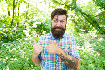 Naklejka na ściany i meble Living a happy life. Happy hipster giving thumbs ups gesture on natural landscape. Emotional guy with long mustache and beard hair on happy face. Bearded man with happy emotions in summer style