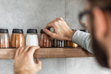 close up. a man takes spices from the kitchen shelf