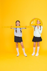 Learning school geometry. School children with measuring instruments on yellow background. Cute...