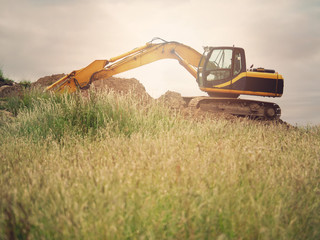 Excavator in a field, Back lit, Soft contrast, Concept, heavy industry, equipment, construction,