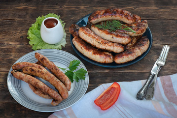 A grilled sausages on a plate on a kitchen table background.