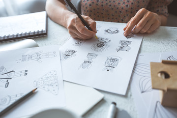 Animator designer draws sketches of various characters. Creating illustrations on paper for...