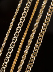 Five gold chain necklaces close up