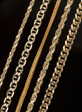 Five gold chain necklaces close up