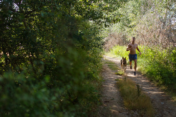 runner running across the field with his dog