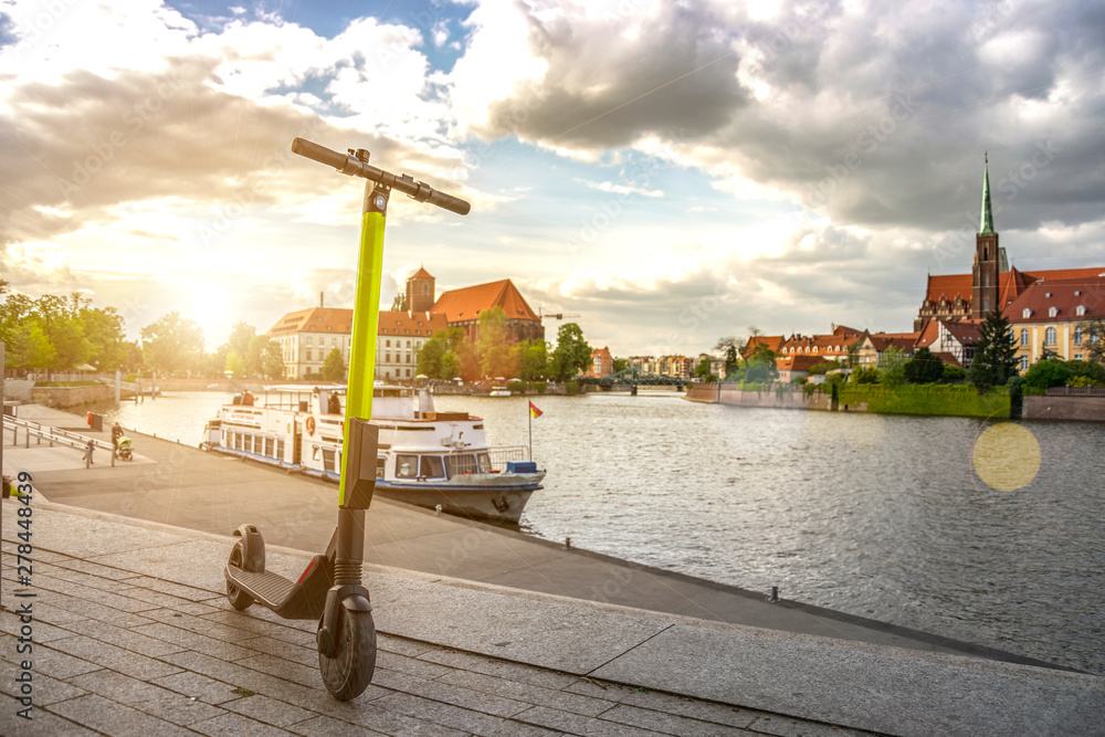 Wall mural electric kick modern scooter at sunset. eco alternative transport concept.