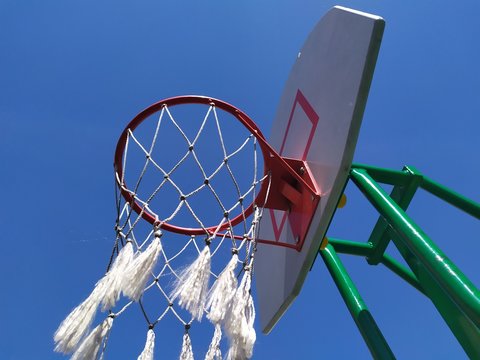 White and red basketball hoop photo on blue sky 