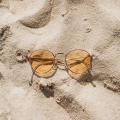 Tropical beautiful beach with white sand, foot steps and yellow sunny sunglasses.  Summer travel or...