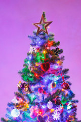 Christmas tree with multicolor led lights and purple background