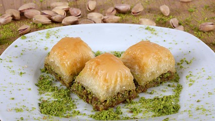 the best turkish baklava Fresh and delicious pistachios together with pistachios on a white plate close up