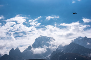 Fototapeta na wymiar Helicopter high above mountian peaks