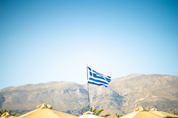 Greek flag with blue sky and mountains in background - 278452060