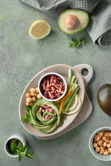 Keto diet, top view of avocado rose salad with bacon cubes and smoked cheese on green table