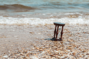 Fototapeta premium Hourglass on the beach, ocean. The concept of transience of time.