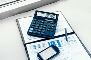 Fototapeta na wymiar calculator, smartphone and financial documents on the businessman's Desk