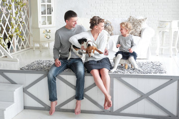 parents and little girl playing with a dog