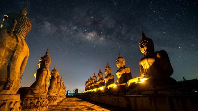 Time lapse of milky way moving above Buddha statues in the Buddha park, Thailand