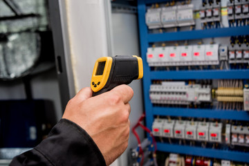 Technician use infrared thermal imaging camera to check temperature at fuse-box