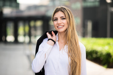 Smiling young business woman walking outdoors