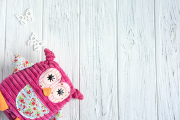 Design greeting card for girls. Toy owl and butterflies on a wooden background. Frame for greeting card text. It's a girl