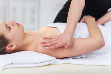 Fototapeta na wymiar Young female masseur making massage in spa salon.