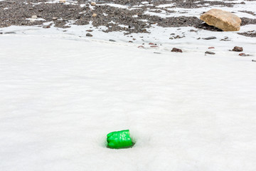 Garbage scattered over snowy mountain. Let's save the planet and recycle the excess garbage. Pollution Concept