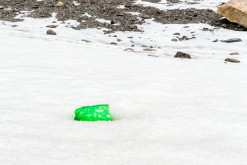 Garbage scattered over snowy mountain. Let's save the planet and recycle the excess garbage. Pollution Concept