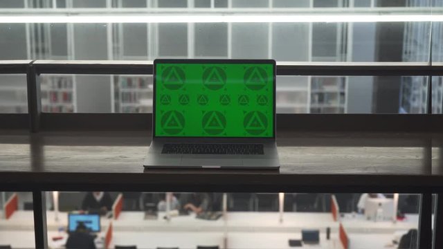 Green Screen Laptop on the Table in Office. 4K Close Up. Mock up shot. Interior Light.  Blurred Background of People Working.