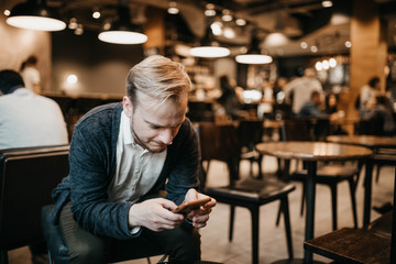 hipster man with glasses sitting in a cozy cafe