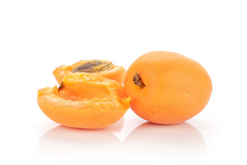 Group of one whole two halves of fresh deep orange apricot with a stone isolated on white background