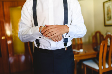 Man putting on a white shirt to dress elegantly.