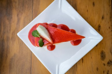 Closeup stawberry cake on white dish and the spoon,Top view