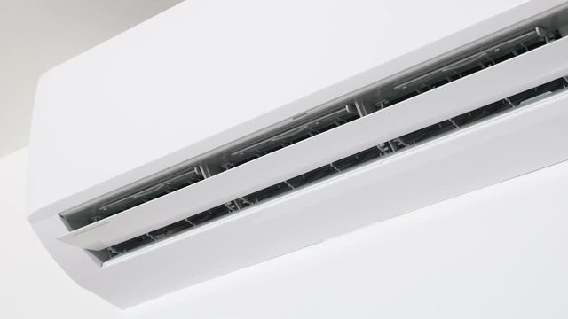Flat air conditioner on white wall in room. Closeup