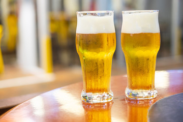 two glasses of draft beer on wooden table top