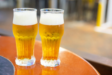 two glasses of draft beer on wooden table top
