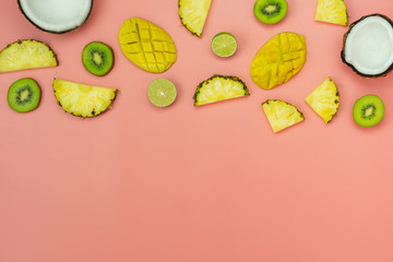 Table top view fruit tropical with spring summer holiday & vacation  background concept.Arrangement sliced various pineapple kiwi mango lemon and lime coconut on  pink paper.flat lay & copy space.