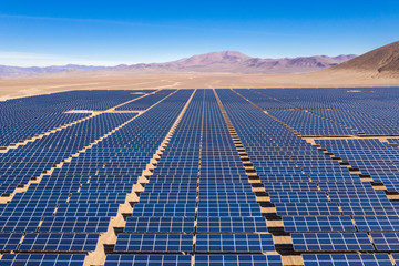 Aerial view of hundreds solar energy modules or panels rows along the dry lands at Atacama Desert,...