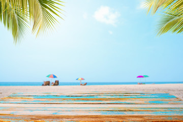 Top of wood table with seascape, palm leaf, calm sea and sky at tropical beach background. Empty ready for your product display montage.  summer vacation background concept.